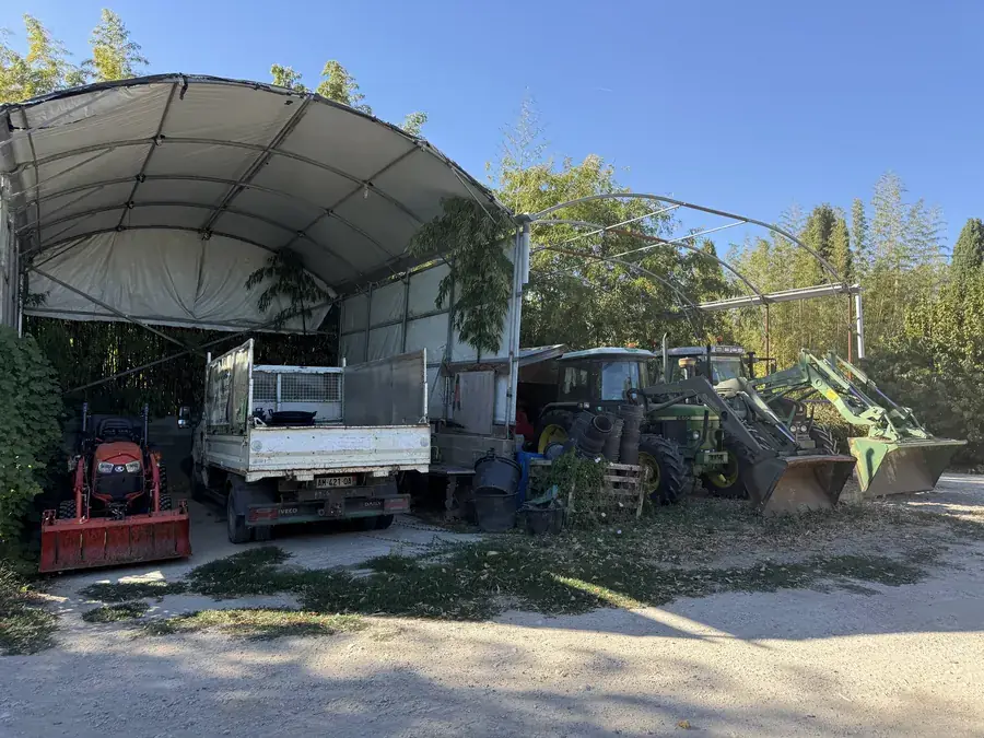 Tracteurs, broyeur et plateau rangés sous abri